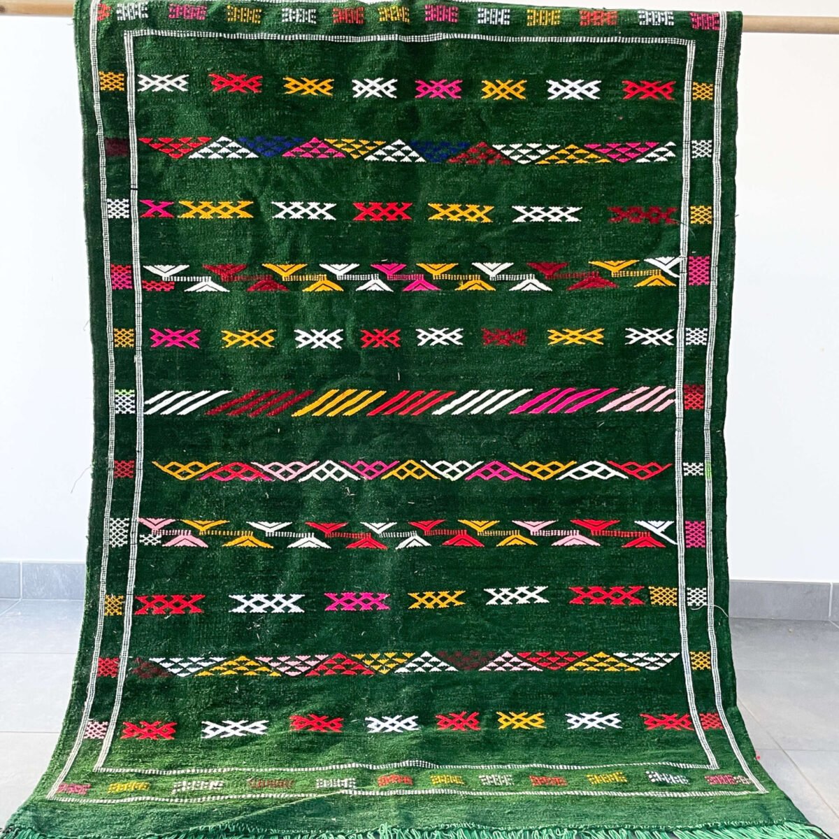 Le Tapis Berbère couleur vert est une pièce de décoration unique, à la croisée de la tradition et de la modernité. Contrairement aux teintes naturelles plus classiques, la couleur verte apporte une note audacieuse et rafraîchissante à votre intérieur. Fabriqué artisanalement dans les montagnes marocaines, ce tapis combine l’élégance du design berbère avec le confort d’une laine naturelle épaisse et chaleureuse. C’est l’option idéale pour ceux qui souhaitent intégrer une pièce forte et vivante dans leur décoration.