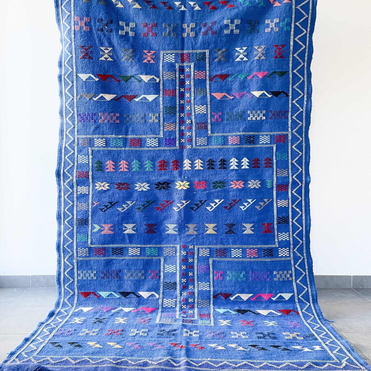 Le tapis berbère bleu est une pièce de décoration audacieuse et raffinée qui allie le charme de l’artisanat berbère au dynamisme de la couleur. Longtemps réservé aux teintes naturelles, le tapis marocain adopte aujourd’hui des coloris plus contemporains comme le bleu, tout en conservant l’authenticité de sa fabrication. Ce tapis tissé à la main dans les montagnes marocaines devient une véritable œuvre d’art textile, idéale pour donner du caractère à n’importe quelle pièce.